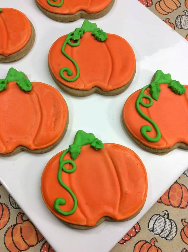 pumpkin cut out cookies decorated  with orange and green frosting