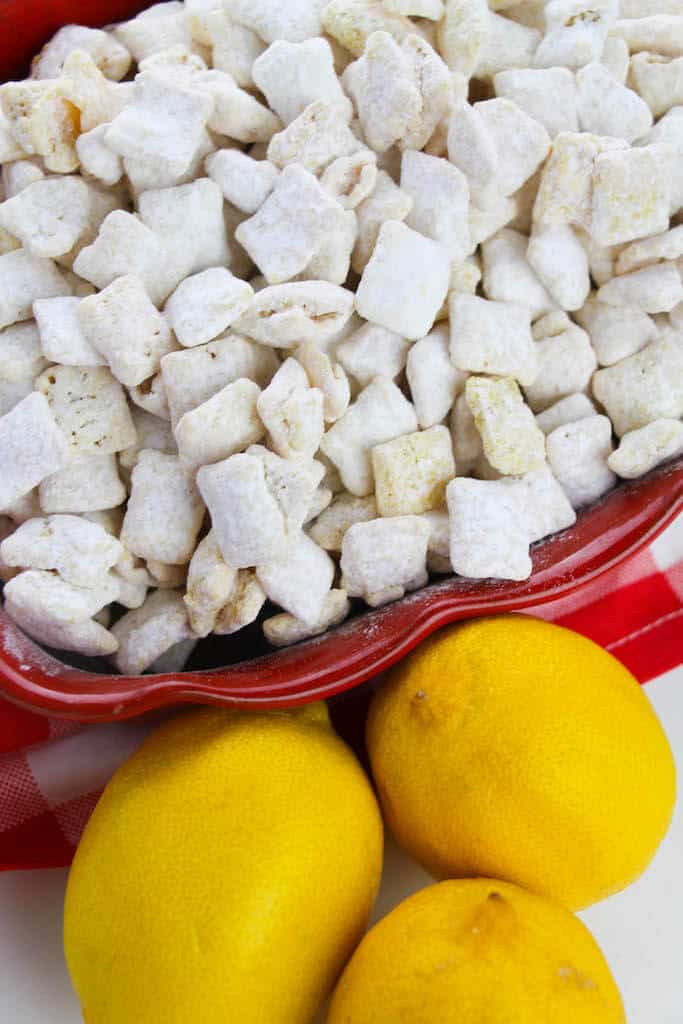 different angles of lemon flavored puppy chow in a red bowl with lemons next to it. 