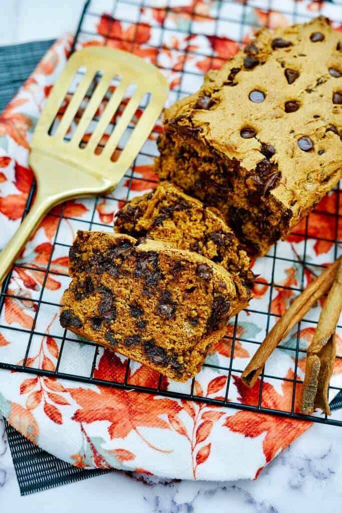 cut up load of pumpkin bread with chocolate chips on a cooling rack.