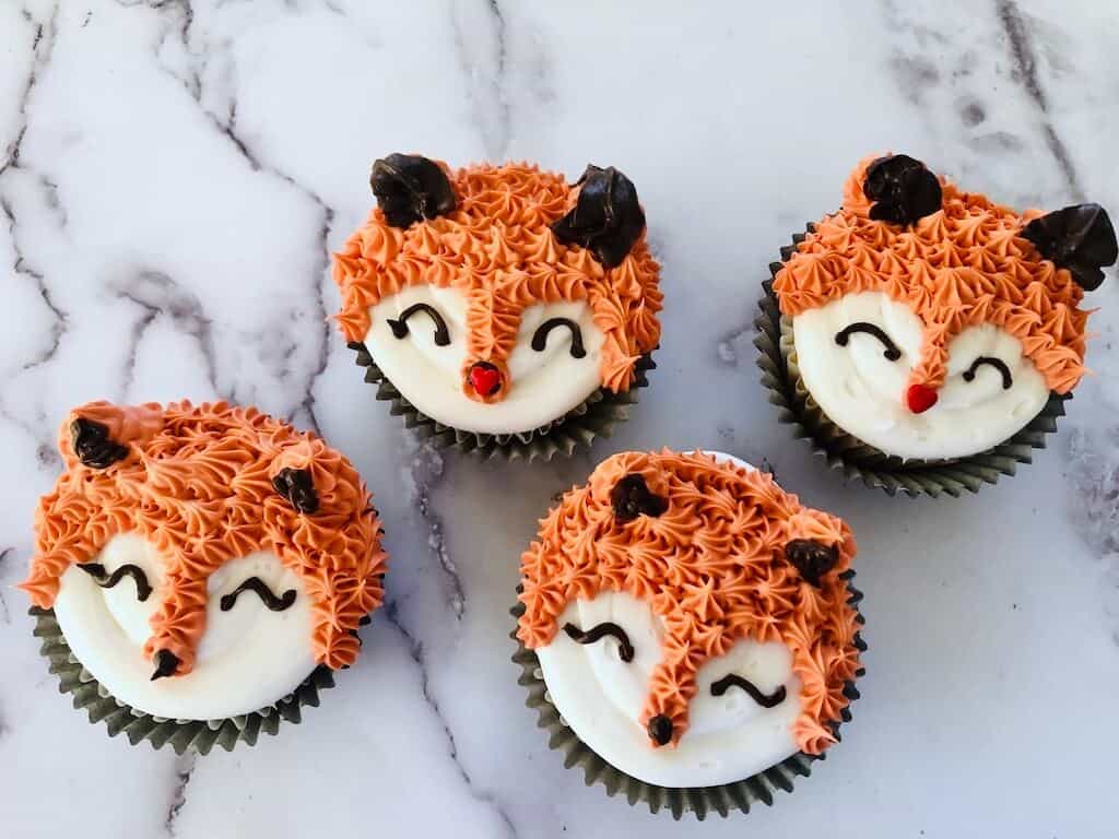 4 orange and white fox themed cupcakes.