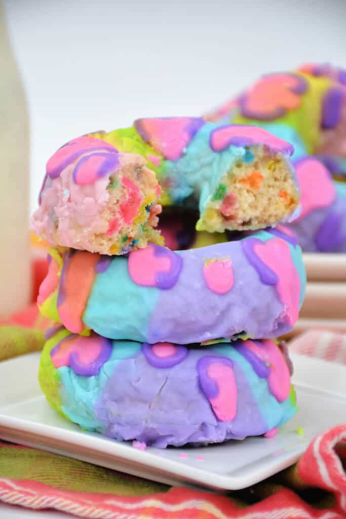 stack of 3 colorful donuts on a plate.