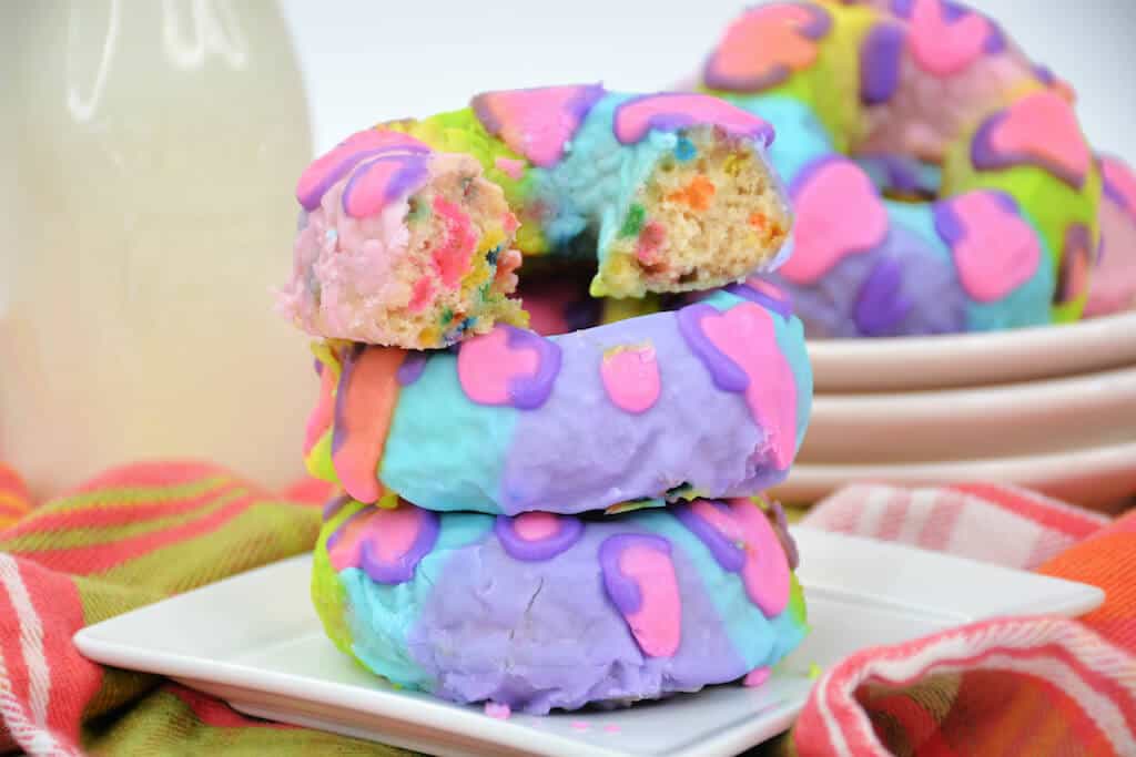 stack of colorful donuts with a bite taken out. 