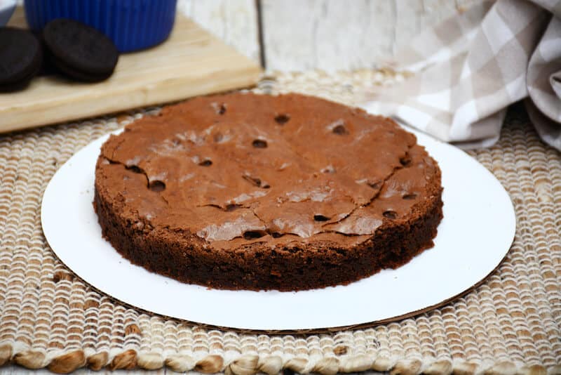 A base layer of brownie on a cake board.