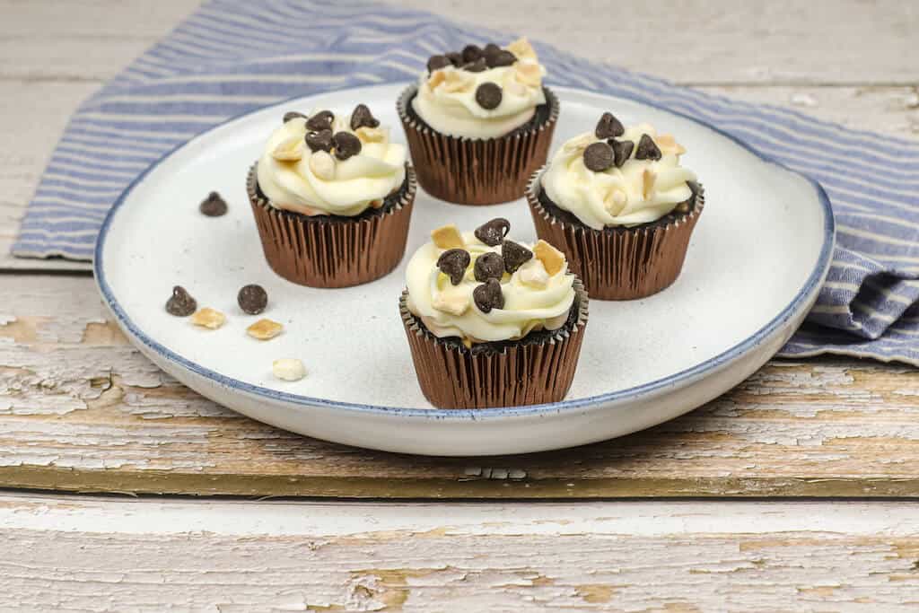Hot fudge cupcakes with chocolate chips and cream in a plate.