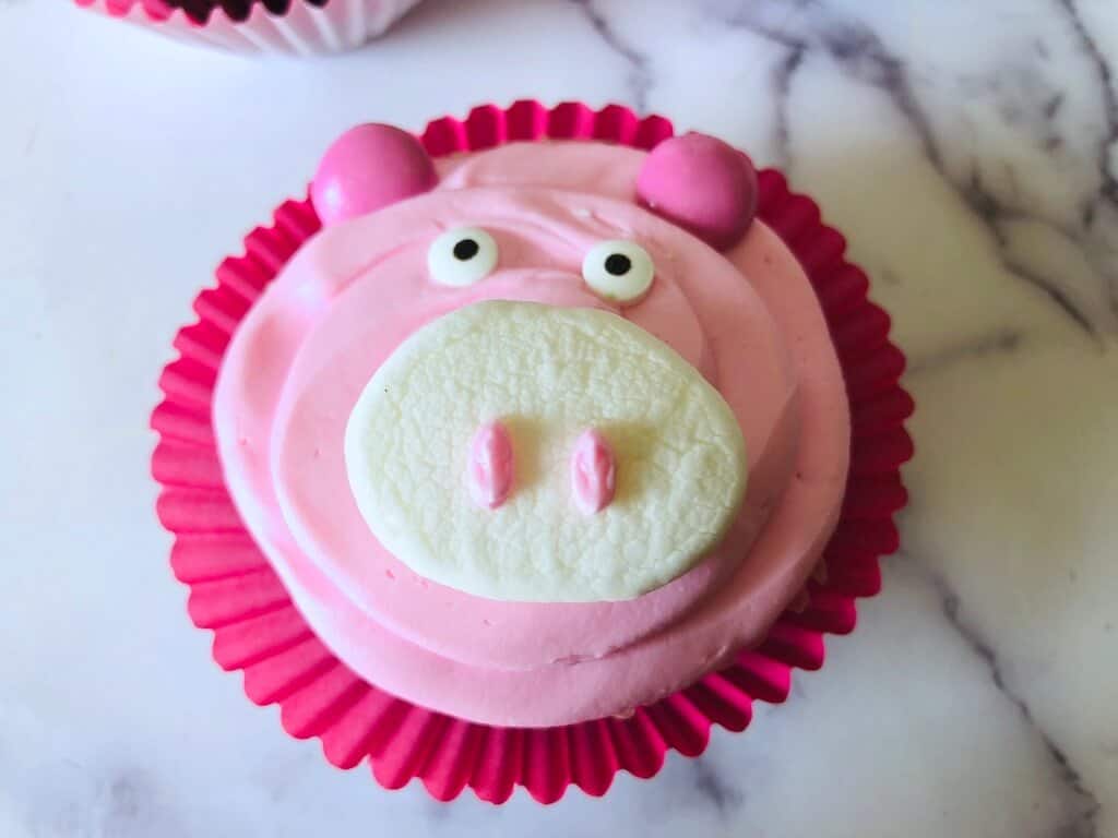 close up of Pink with marshmallow pig cupcake in a disposable cup.