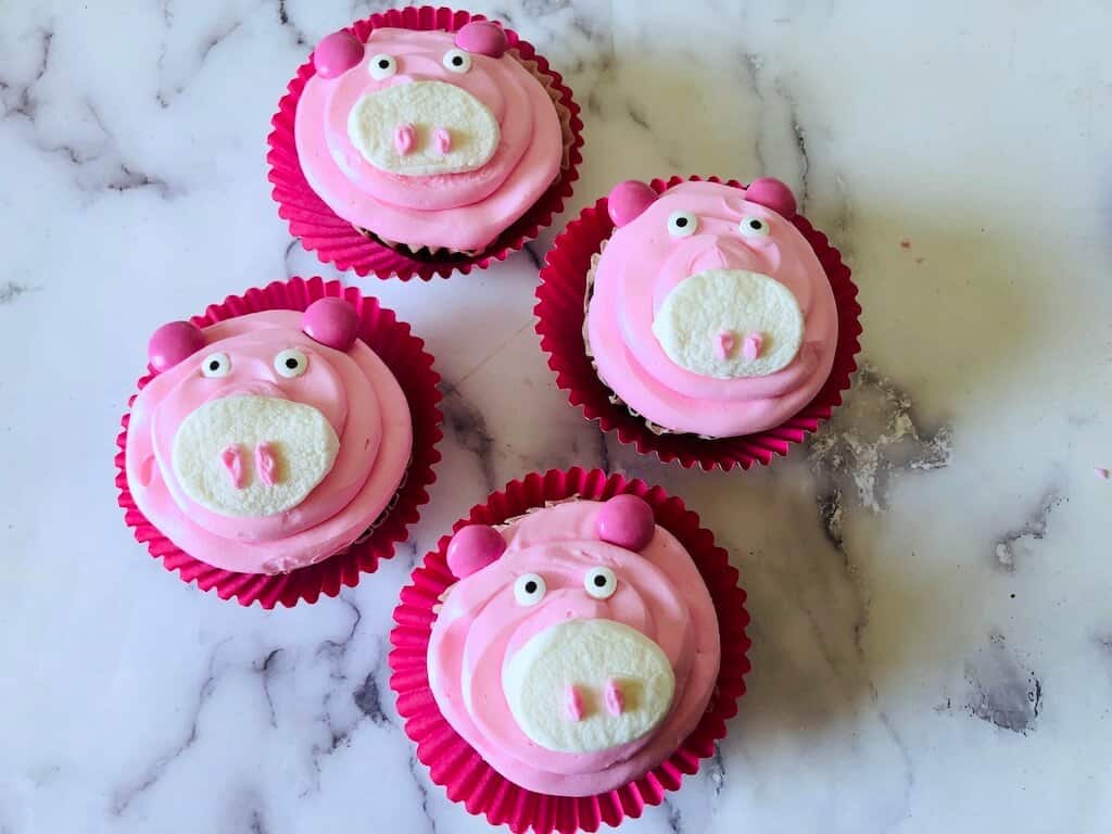 4 frosted pig cupcakes.
