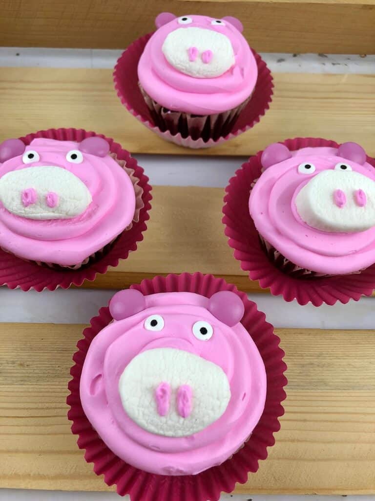 Frosted pink butter cream pig cupcakes.
