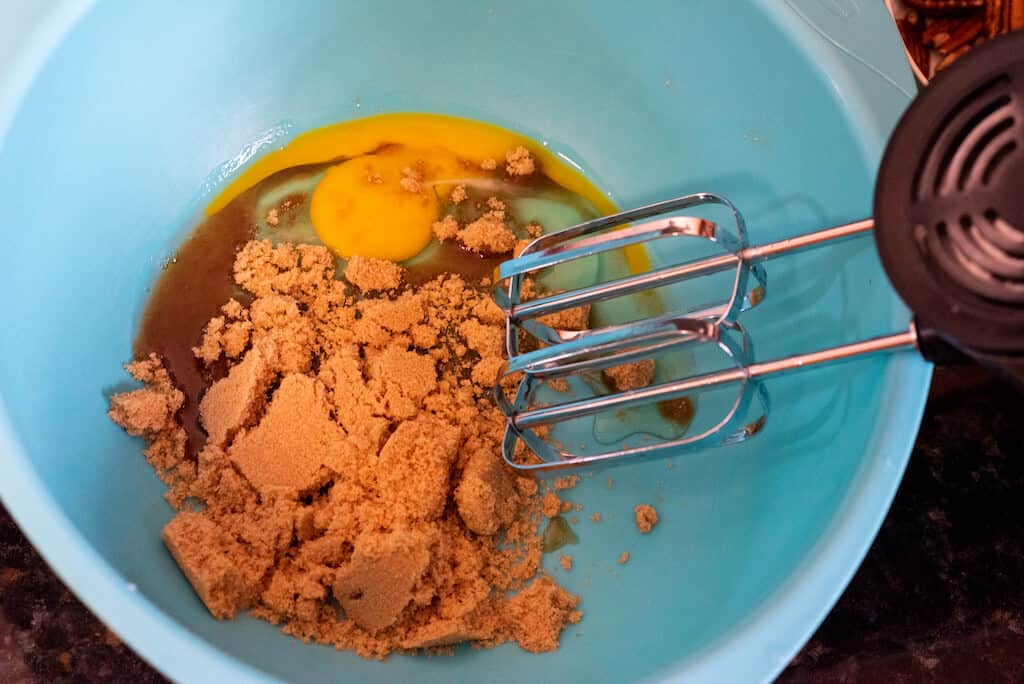 Brown sugar and egg mixing in a bowl.