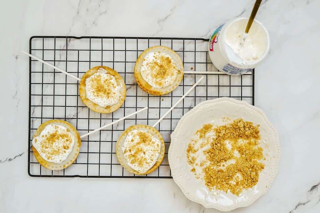 Air fryer s'mores pies with marshmallow's fluff on a cooling rack.