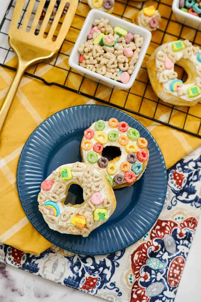 Air fryer cereal donuts with lots of cereal pieces on top.